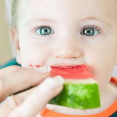 dziecko-je-owoc-bogaty-w-wode Niemowlę jedzące owoce bogate w wodę – uzupełnianie płynów przez dietę